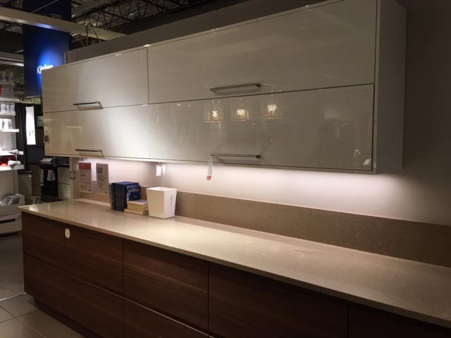 Sample kitchen set up with white and brown cabinets in IKEA warehouse