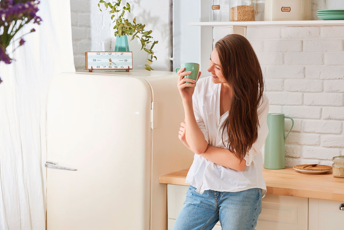 Woman Drinking Coffee in Kitchen