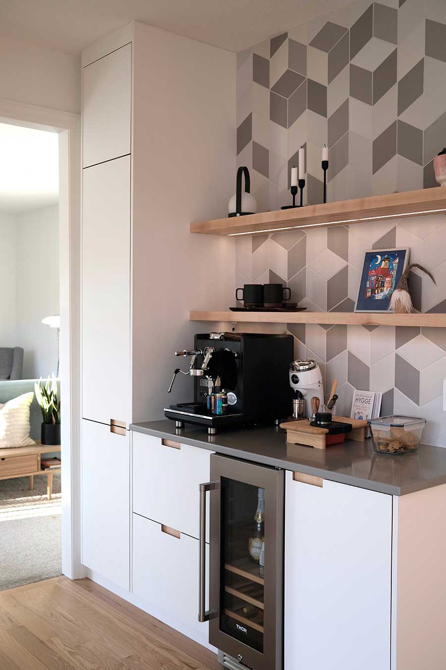 Espresso machine on dark countertop and white cabinets