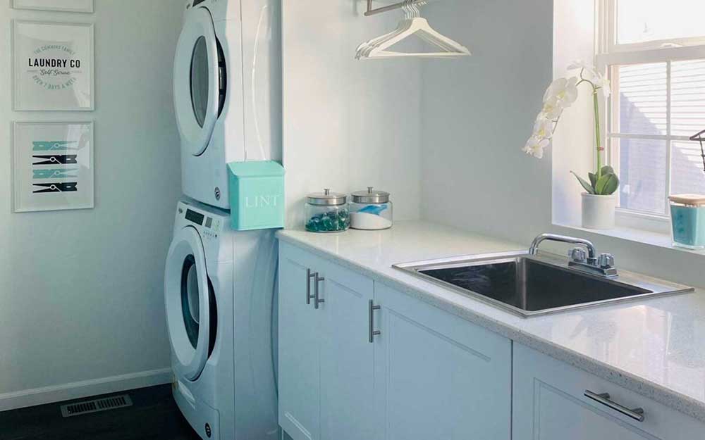 All white laundry room with stacked washer/dryer