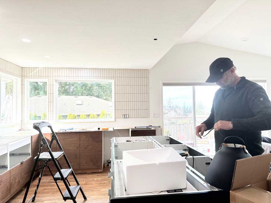 Kitchen remodel team installing island cabinets