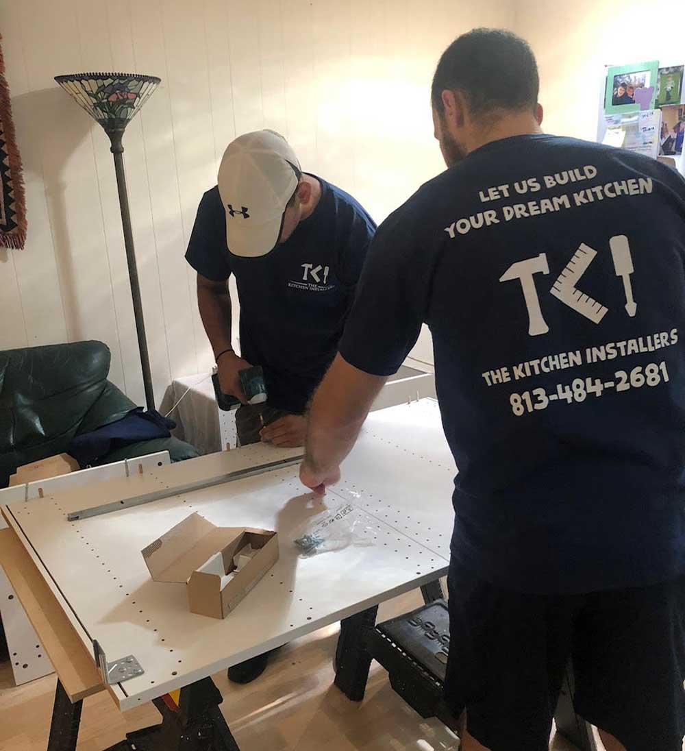 The Kitchen Installers working on measuring cabinets