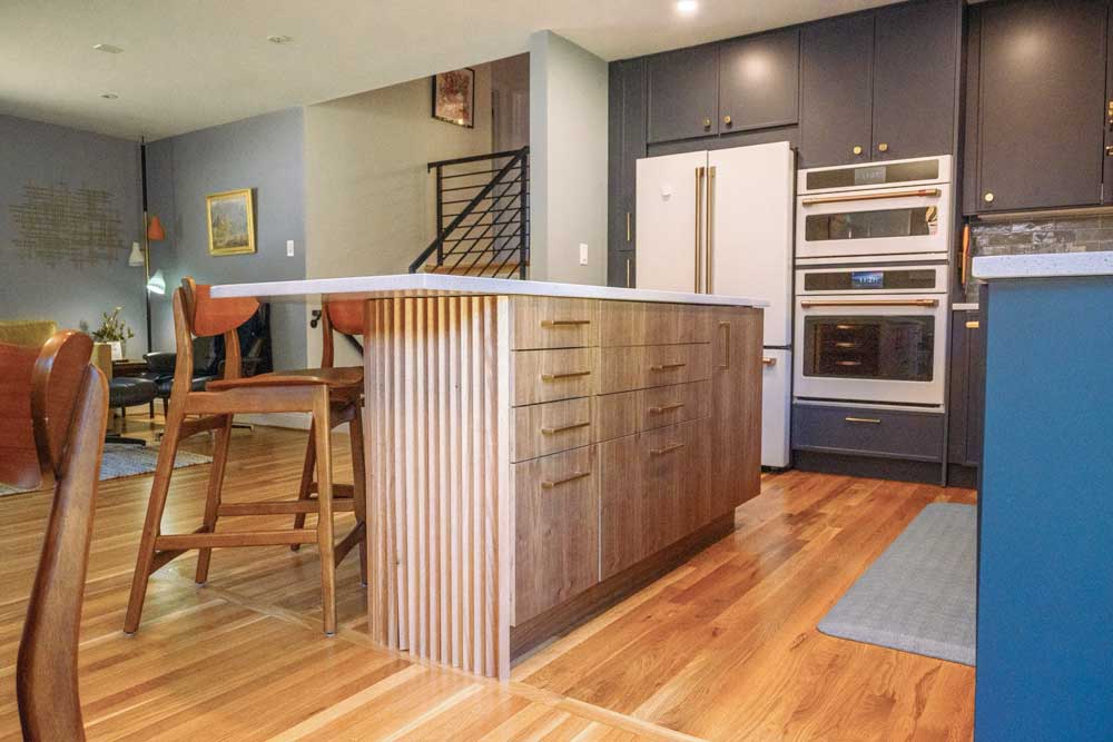 Dark upper and base cabinets are balanced out by white quartz countertops and a light walnut kitchen island