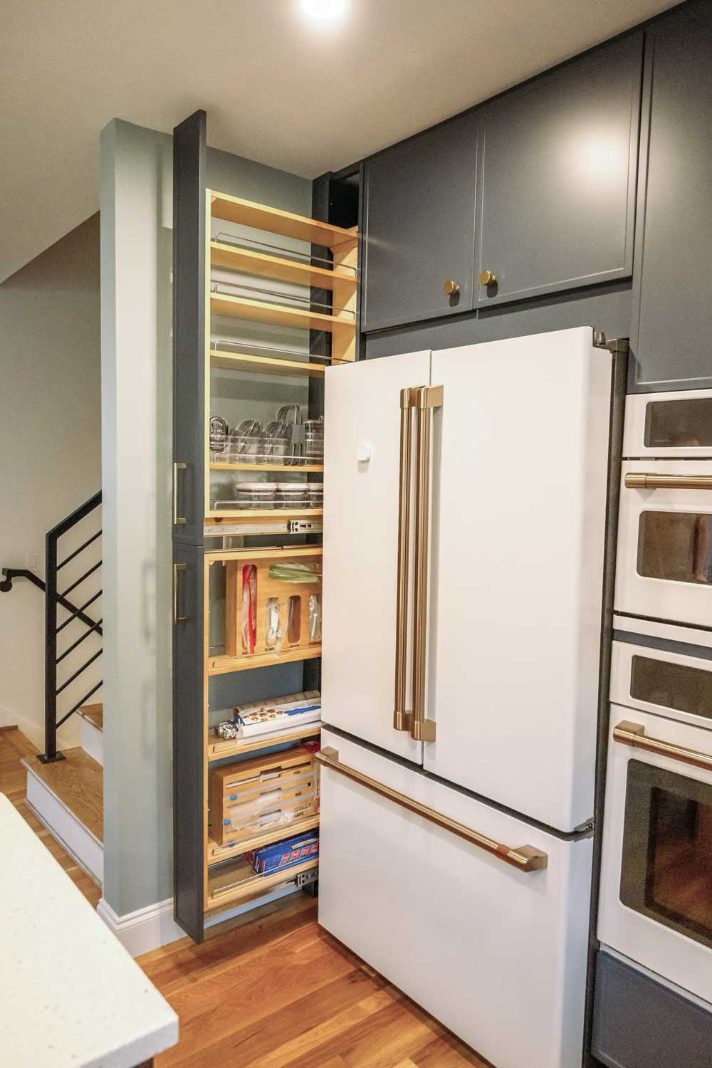 Custom IKEA upper cabinets and slide out storage around the refrigerator